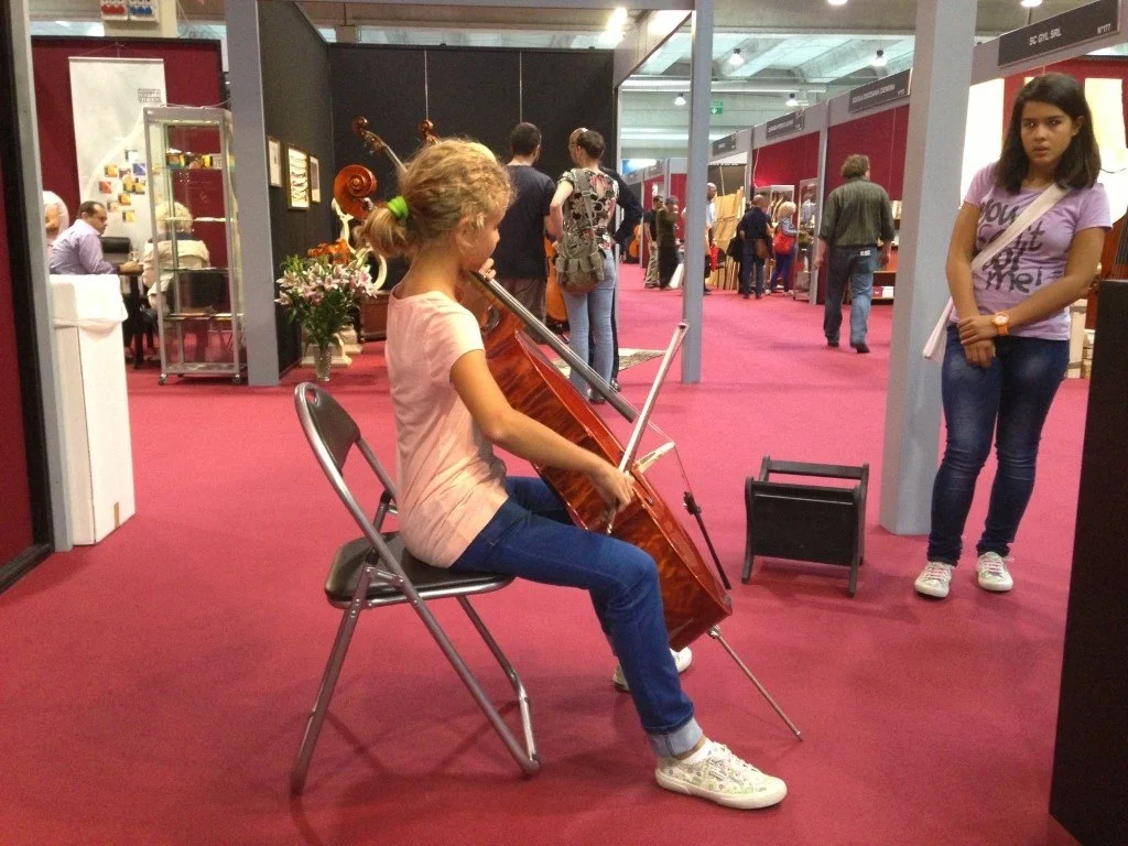 Una giovane musicista suona un violoncello di Gregorio Martini sullo stand